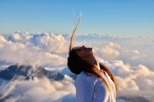 mujer en la cumbre del bienestar entre nubes y sueños